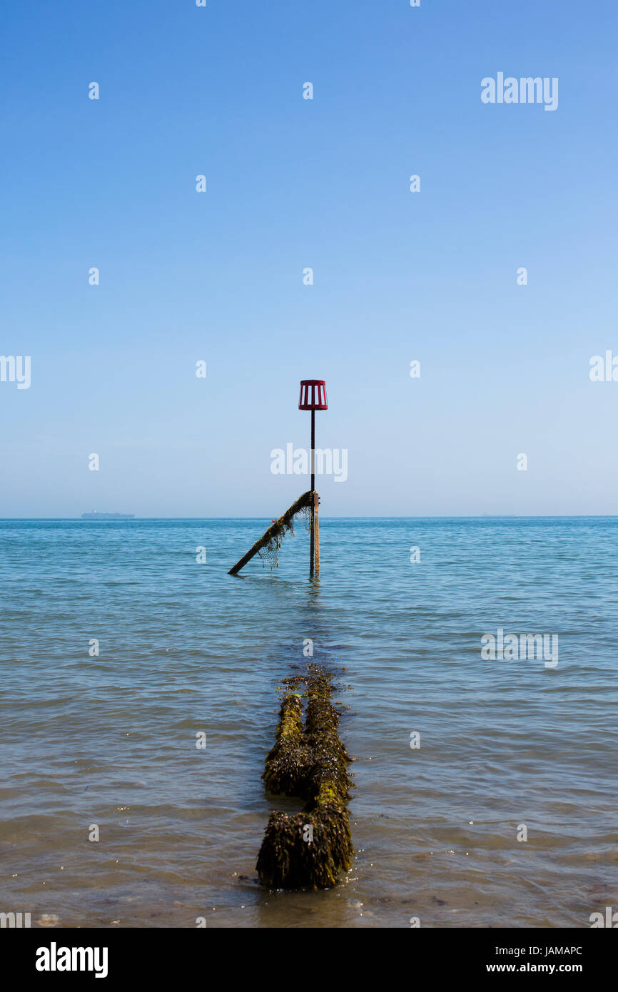 Un marqueur rouge à la fin d'un épi sur la plage de Sandown, Isle of Wight, sur une journée ensoleillée. Banque D'Images
