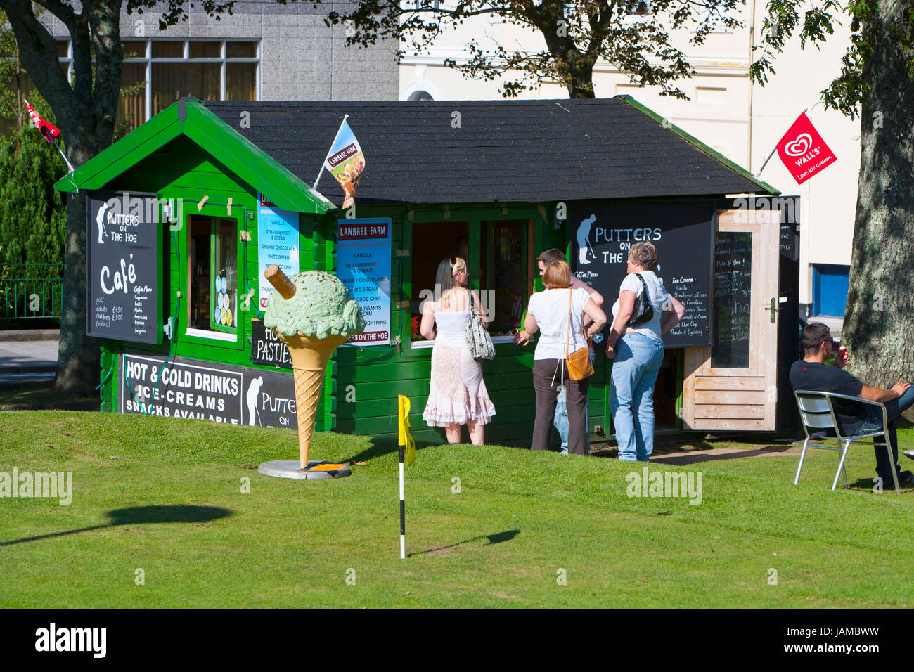 Les jeunes adultes d'acheter des rafraîchissements, du café vert cabane sur un golf à l'extérieur dans le soleil en été journée ensoleillée. grand green ice cream cone Banque D'Images