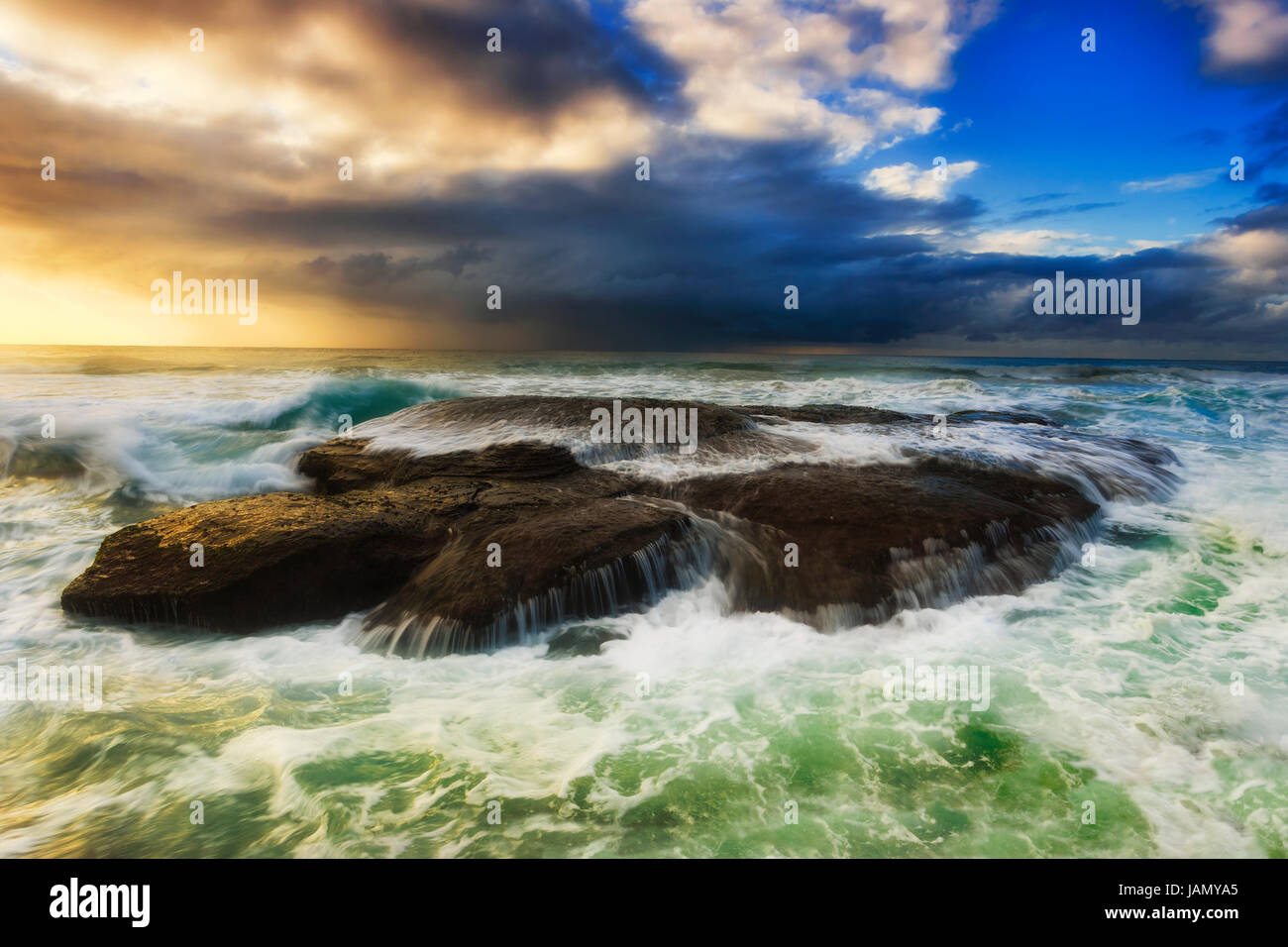 Clody colorés avec lever de soleil sur horizon à Bungan beach à Sydney plages du nord. Débordement de vagues rochers de grès reflétant bien Banque D'Images