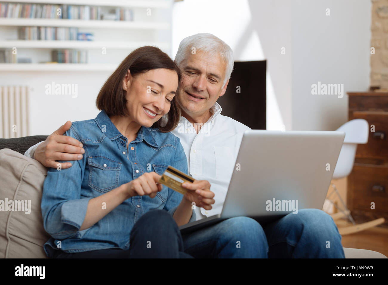 Mature Couple connecté avec un ordinateur portable et des achats en ligne Banque D'Images