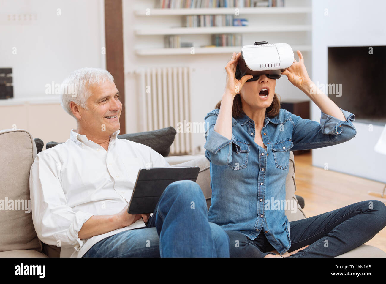 Mature couple casque de réalité virtuelle dans la salle de séjour Banque D'Images