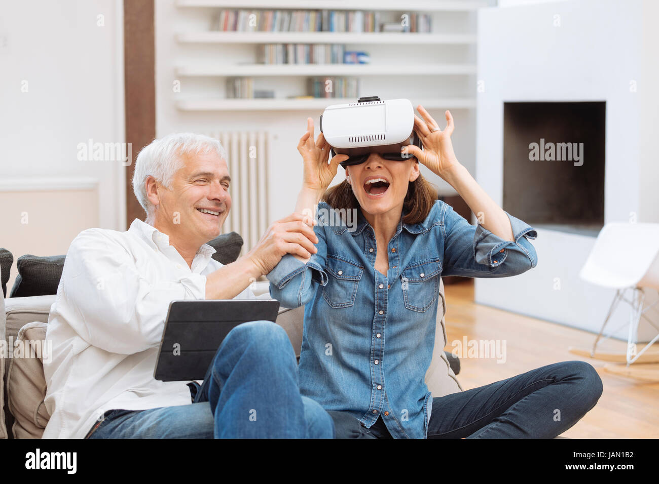 Mature couple casque de réalité virtuelle dans la salle de séjour Banque D'Images