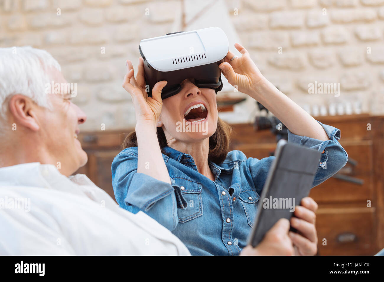 Mature couple casque de réalité virtuelle dans la salle de séjour Banque D'Images