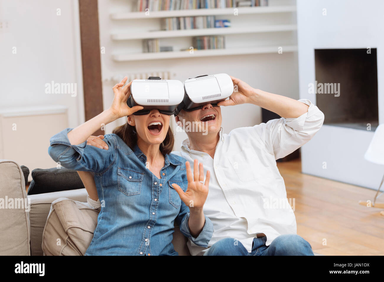 D'âge mûr à l'aide de casque de réalité virtuelle dans la salle de séjour Banque D'Images