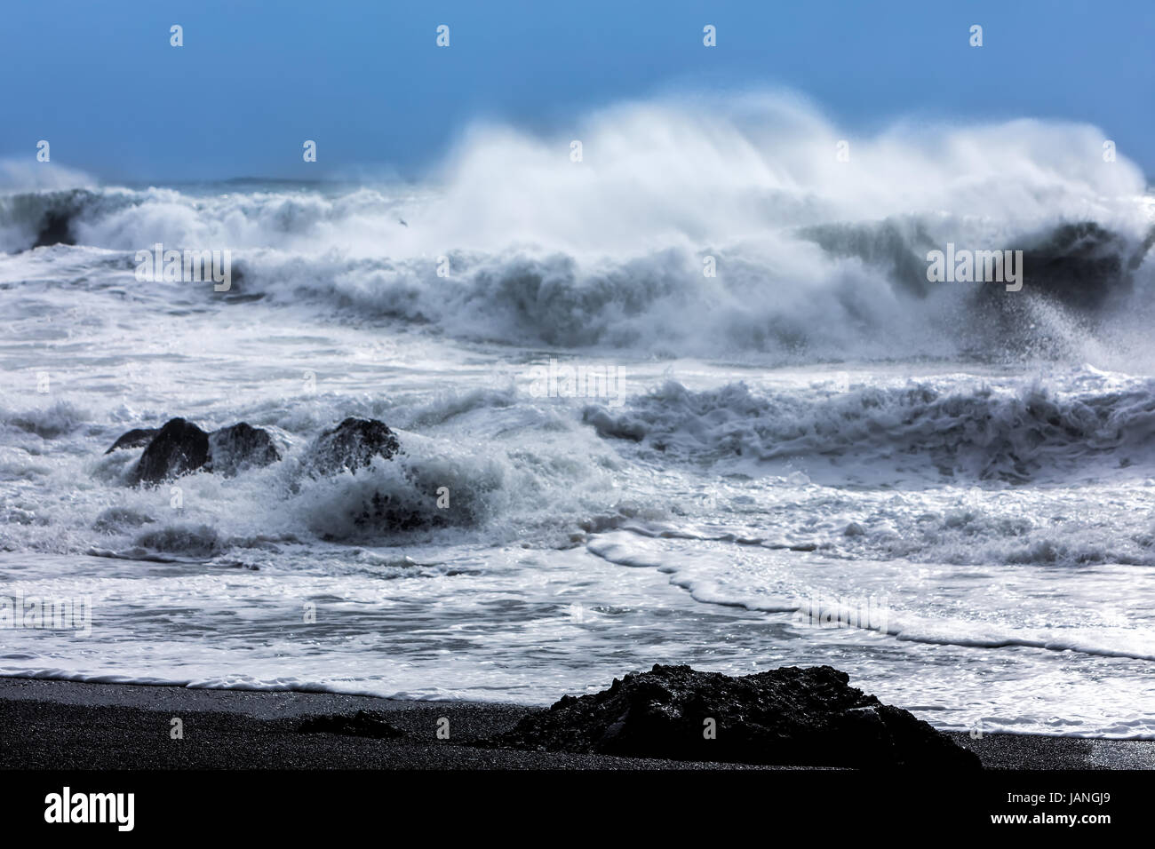 Les vagues turbulentes qui plantent avec grande puissance sur la plage de sable noir de Reynisfjara qui jouit dans le domaine de la Vik en Islande Banque D'Images