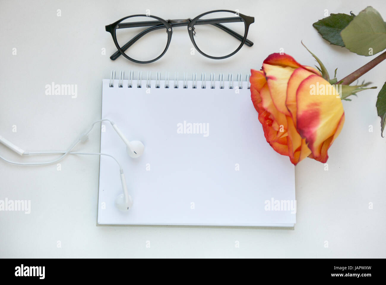 La maquette de l'ordinateur portable de l'art en rouge et jaune, rose casque blanc et de gaz . Vue d'en haut. Place pour le texte. Des fleurs Banque D'Images