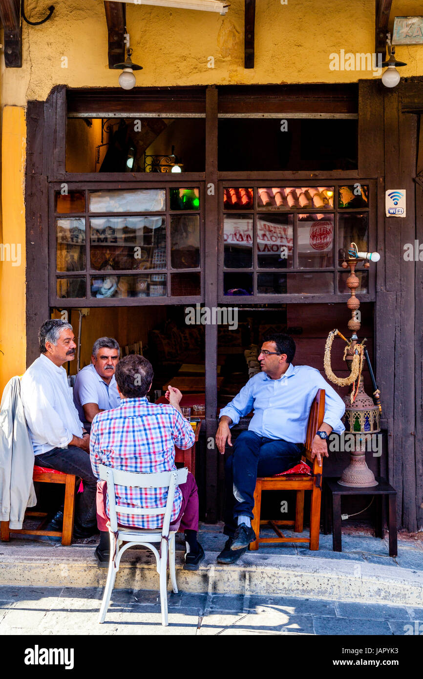 Homme grec s'asseoir à l'extérieur d'un chat café sur la rue 177, Sygrou, la vieille ville de Rhodes, Rhodes, Grèce Banque D'Images