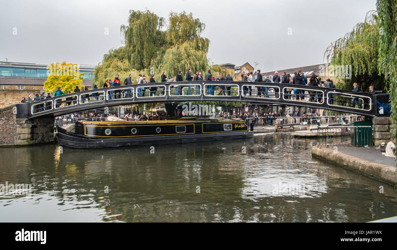 Time Lapse view de personnes traversant un pont sur le canal à Camden Town à l'entrée de la célèbre Lock Market à Londres Banque D'Images