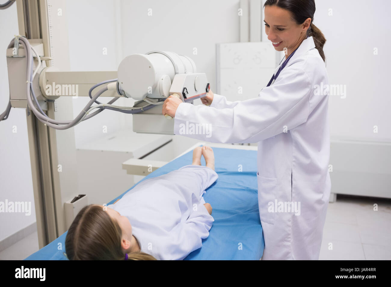 Female doctor holding a radiography la machine sur un patient dans un hôpital Banque D'Images