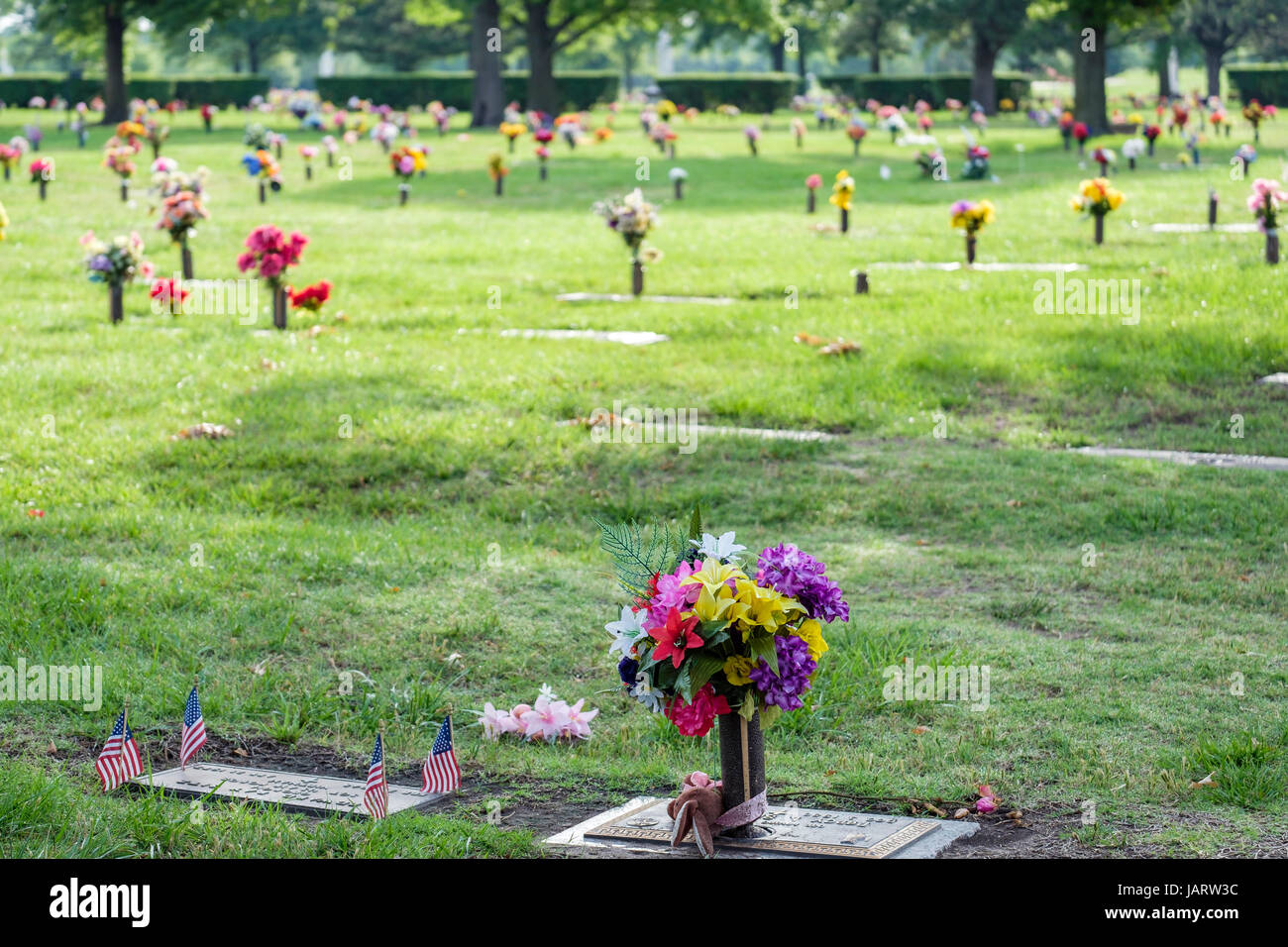 Tombe des décorations florales honorant les morts sur Memorial Day dans un cimetière à Wichita, Kansas, États-Unis. Banque D'Images