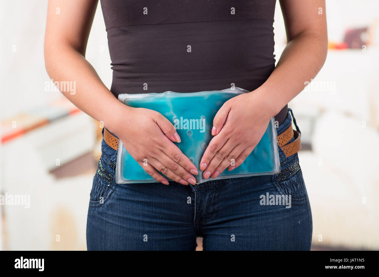 La tenue féminine gel pack de glace sur le genou, la notion médicale, dans l'arrière-plan du bureau. Banque D'Images