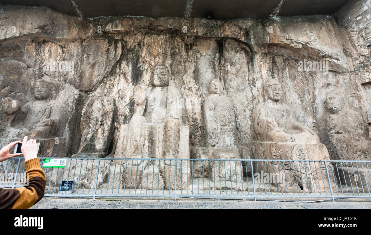 LUOYANG, CHINE - 20 mars 2017 : prendre des photos de la statue de Bouddha sculptée dans Grottes de Longmen (grottes de Longmen). Le complexe a été inscrit à l'ONU Banque D'Images