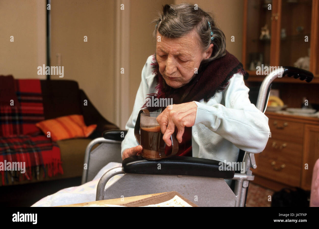 Personnes âgées arthritiques woman in wheelchair boire du café Banque D'Images