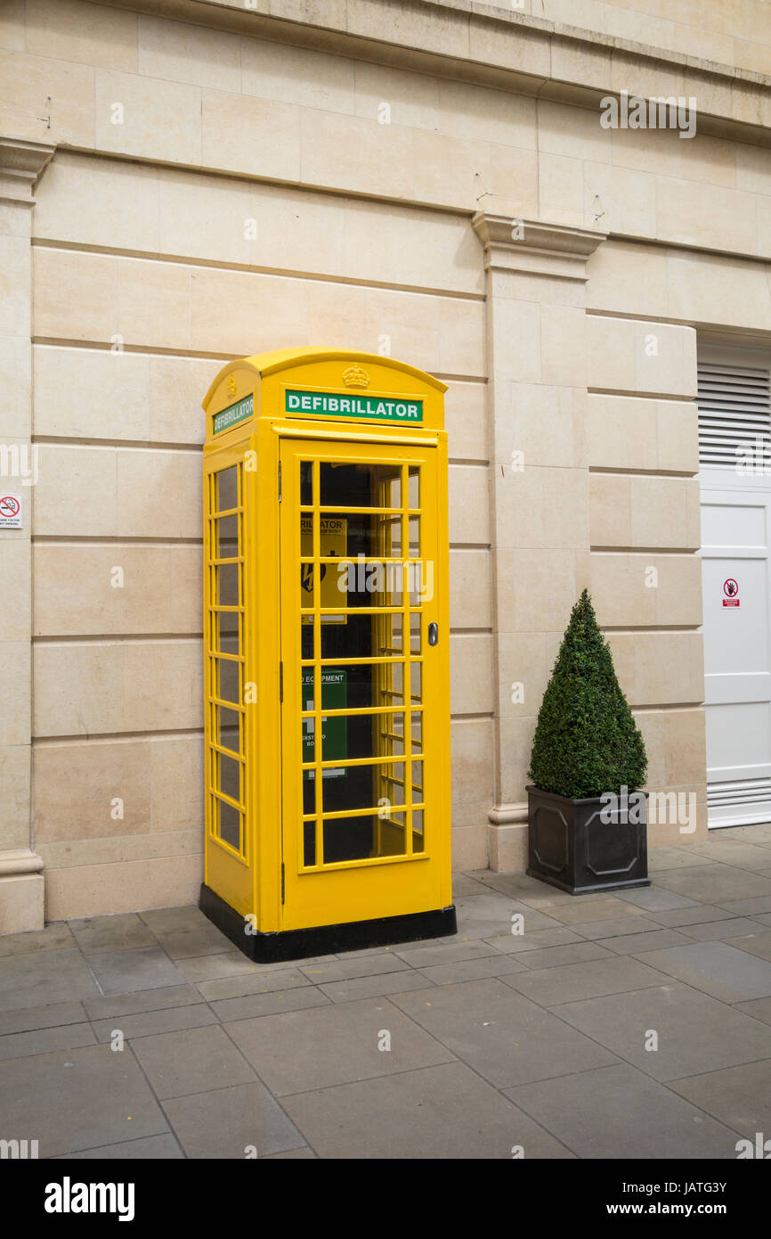 Un défibrillateur électrique automatique, plus l'équipement de premiers soins et téléphone installé dans une cabine téléphonique jaune, Southgate Bâtiment de direction, Bath, Royaume-Uni Banque D'Images