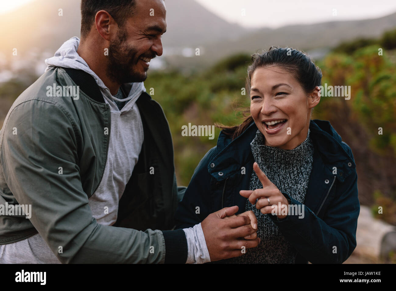 Portrait de couple d'heureux Randonneurs marchant dans la campagne. Jeune homme et femme s'amusant à l'extérieur, sur une période de vacances. Banque D'Images