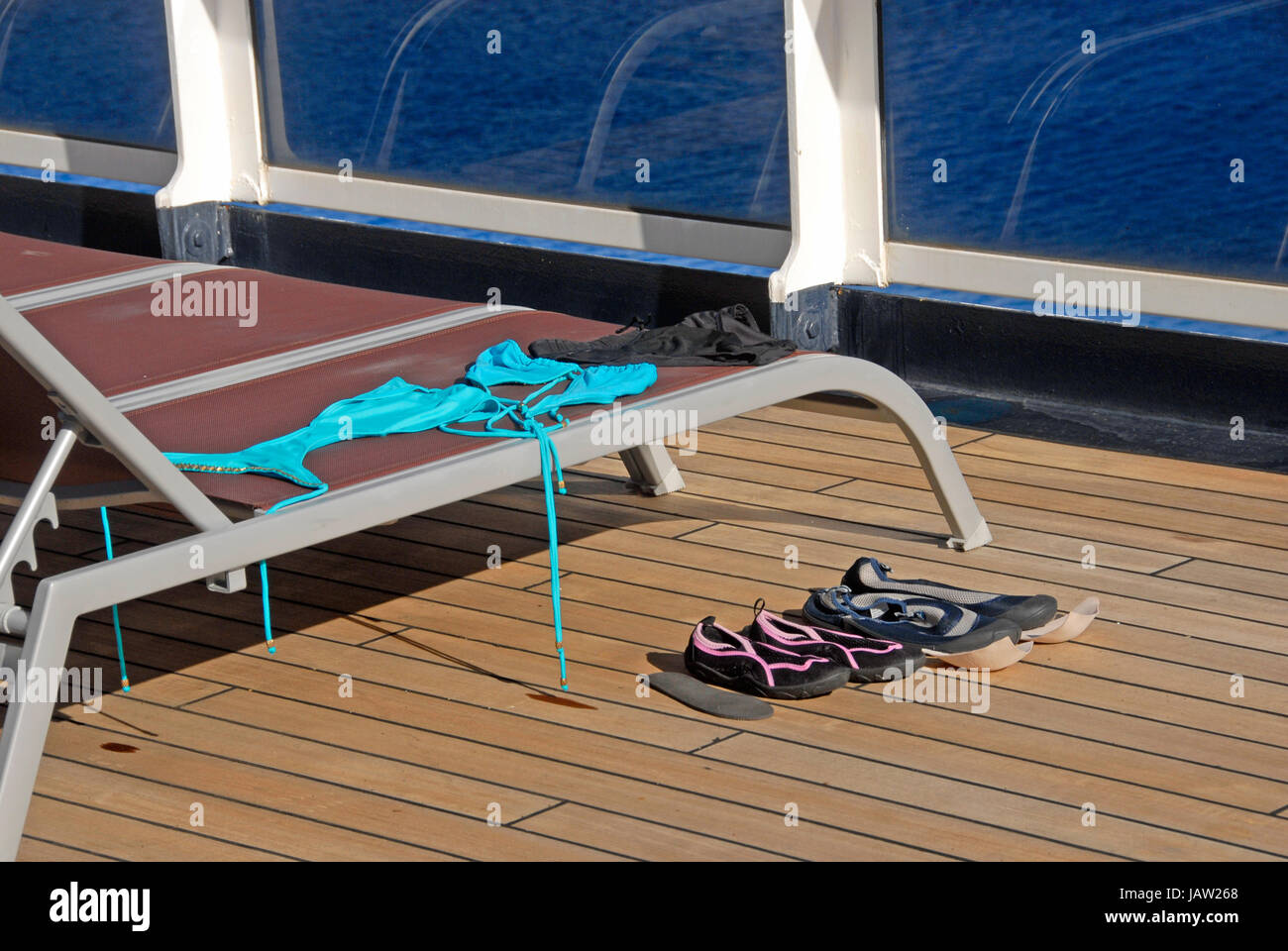 Maillots de bain et sandales laissés à sécher sur le pont du navire de croisière Banque D'Images