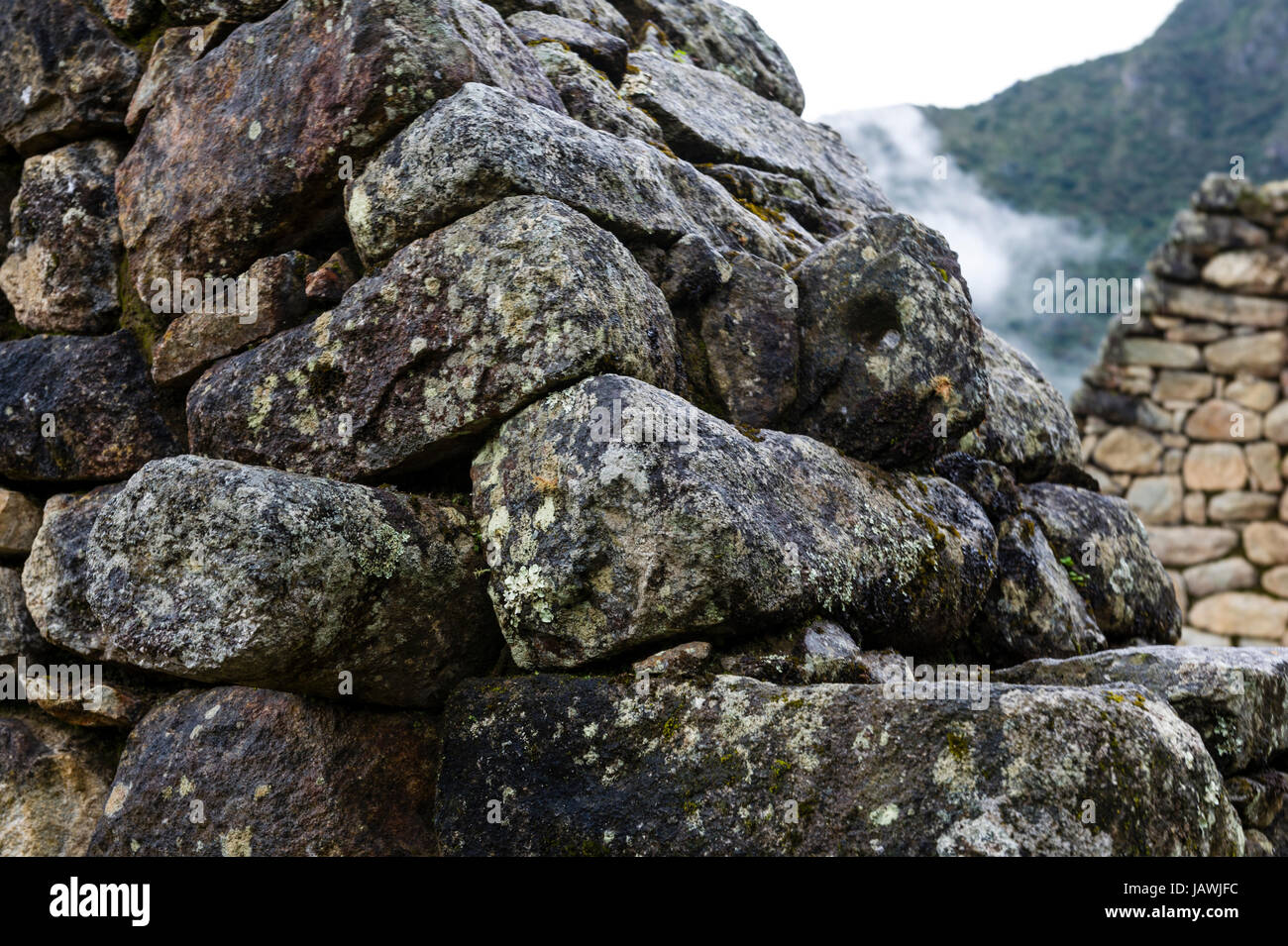 Un détail de pierres empilées pour former un mur dans un bâtiment résidentiel à Machu Picchu. Banque D'Images