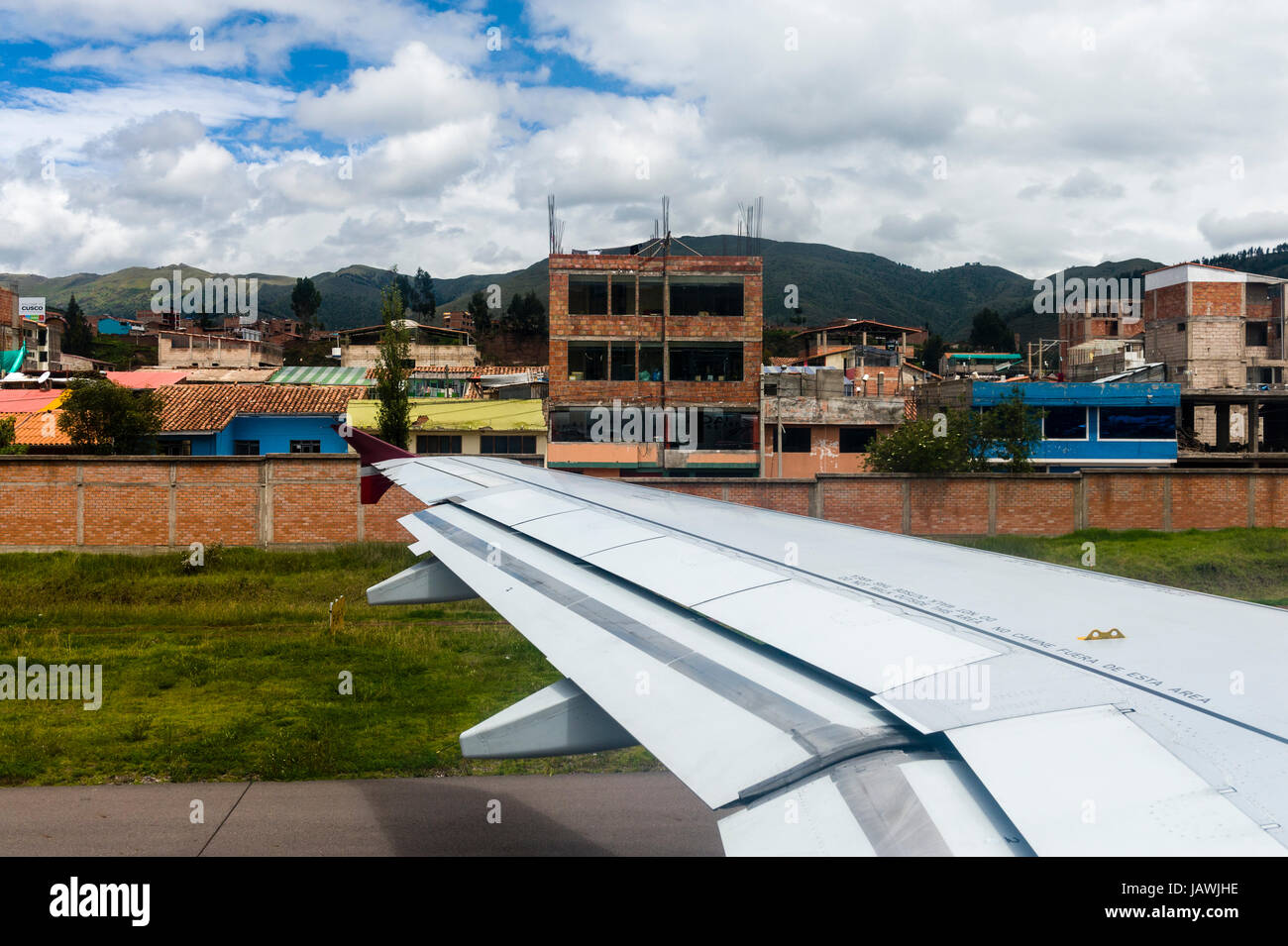 Une aile d'avion décollant d'un aéroport dans les montagnes des Andes. Banque D'Images