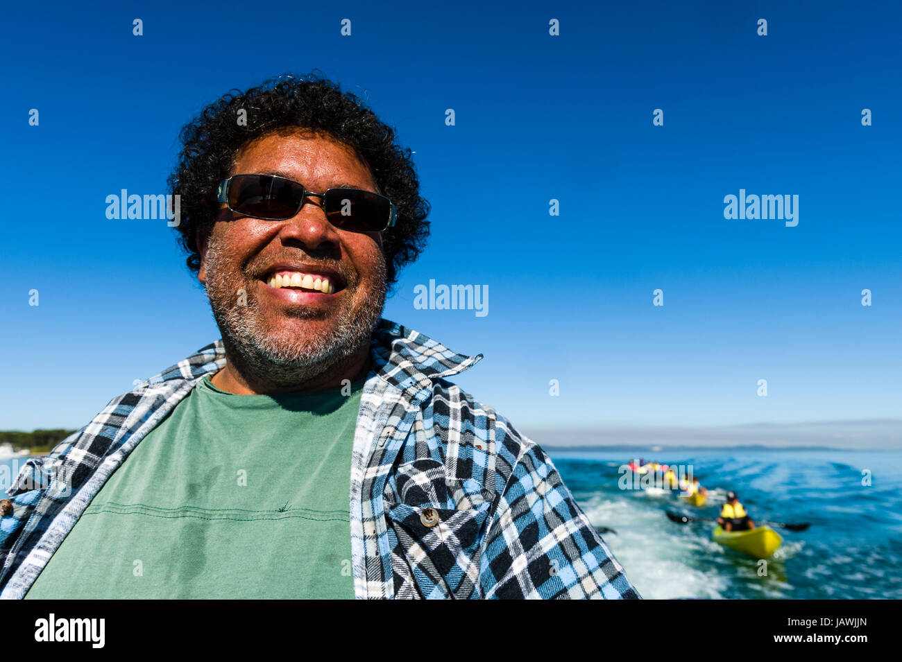 Le visage souriant d'un capitaine de bateau et guide autochtone portant des lunettes de soleil. Banque D'Images