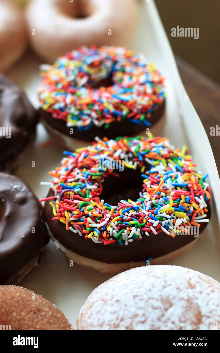 Sprinkles multicolores sur le chocolat de beignes Krispy Kreme Banque D'Images