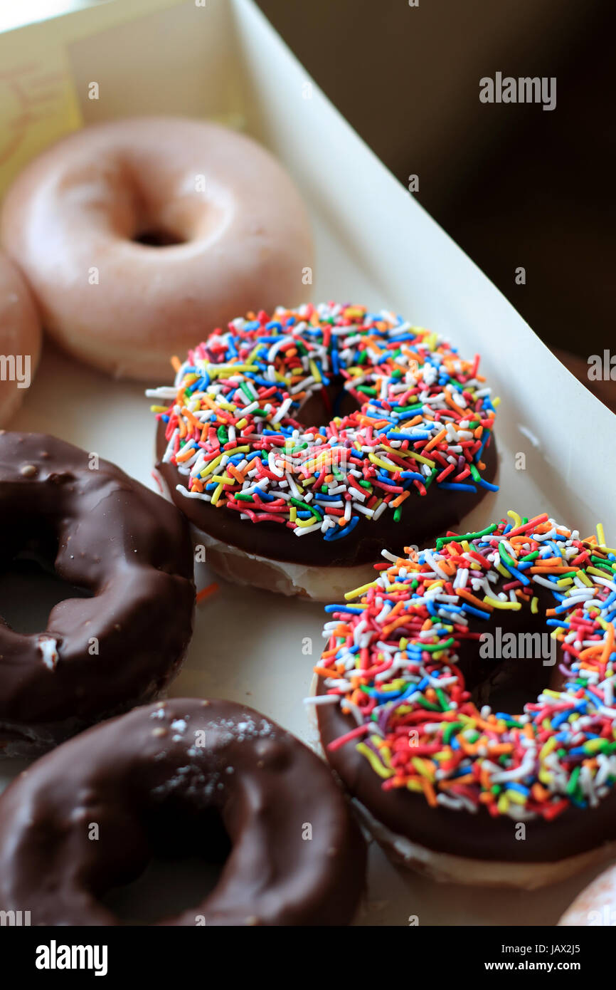 Sprinkles multicolores sur le chocolat de beignes Krispy Kreme Banque D'Images