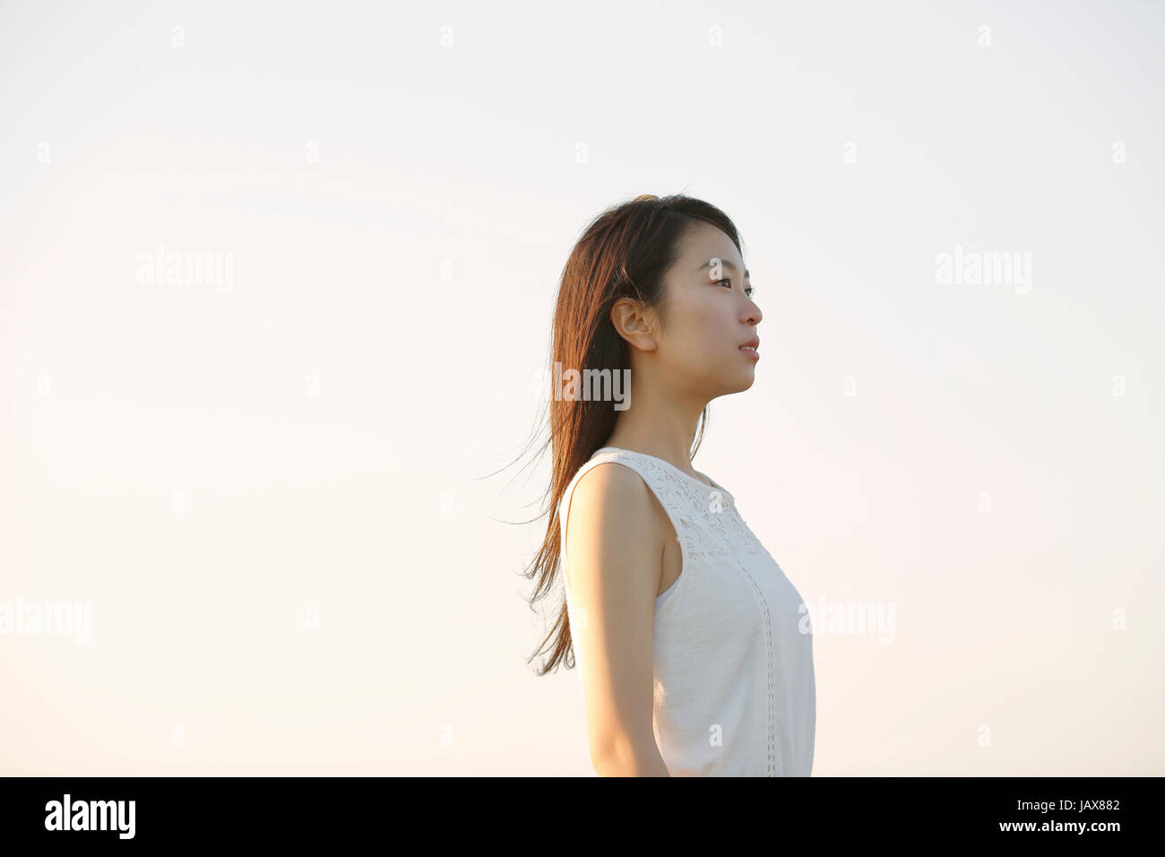 Jeune japonaise en robe blanche lors d'une falaise sur la mer au lever du soleil, Chiba, Japon Banque D'Images