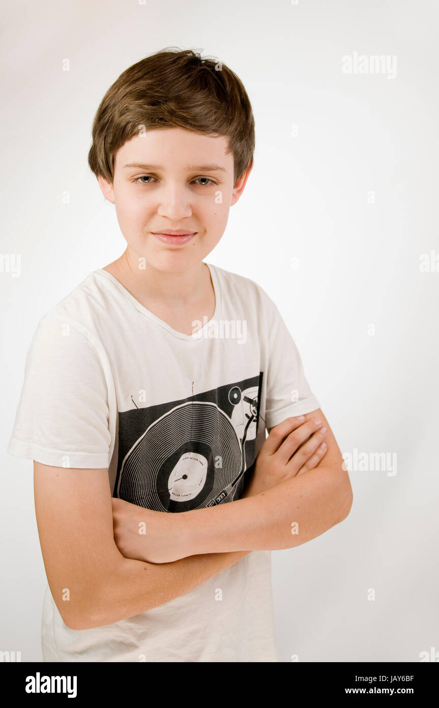 Oberkörper-Porträt eines jungen adolescents männlichen T-Shirt im verschränkten Armen vor und weissen Hintergrund dans Die Kamera lächelnd aus erhöhter Ansicht Banque D'Images