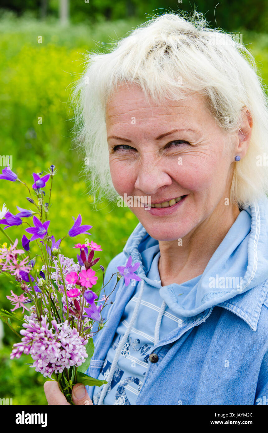 Portrait d'une femme d'âge moyen avec un bouquet de fleurs sauvages Banque D'Images