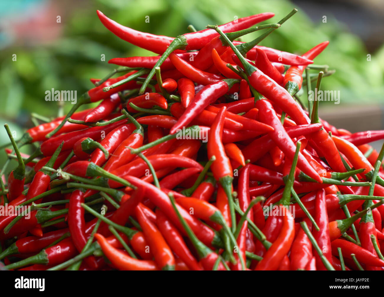 Piments rouges frais close up avec le poivron vert dans l'arrière-plan blured. Ingrédients de cuisson. Banque D'Images