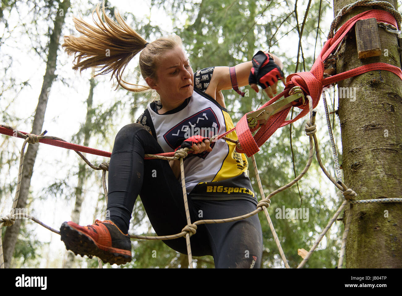 SILICHI/BELARUS - 7 mai 2017 : une dame surmonte vetical obstacle net pendant la course des bisons, un cours d'obstacles, course helt le 7 mai en Silichi, le Bélarus. Banque D'Images