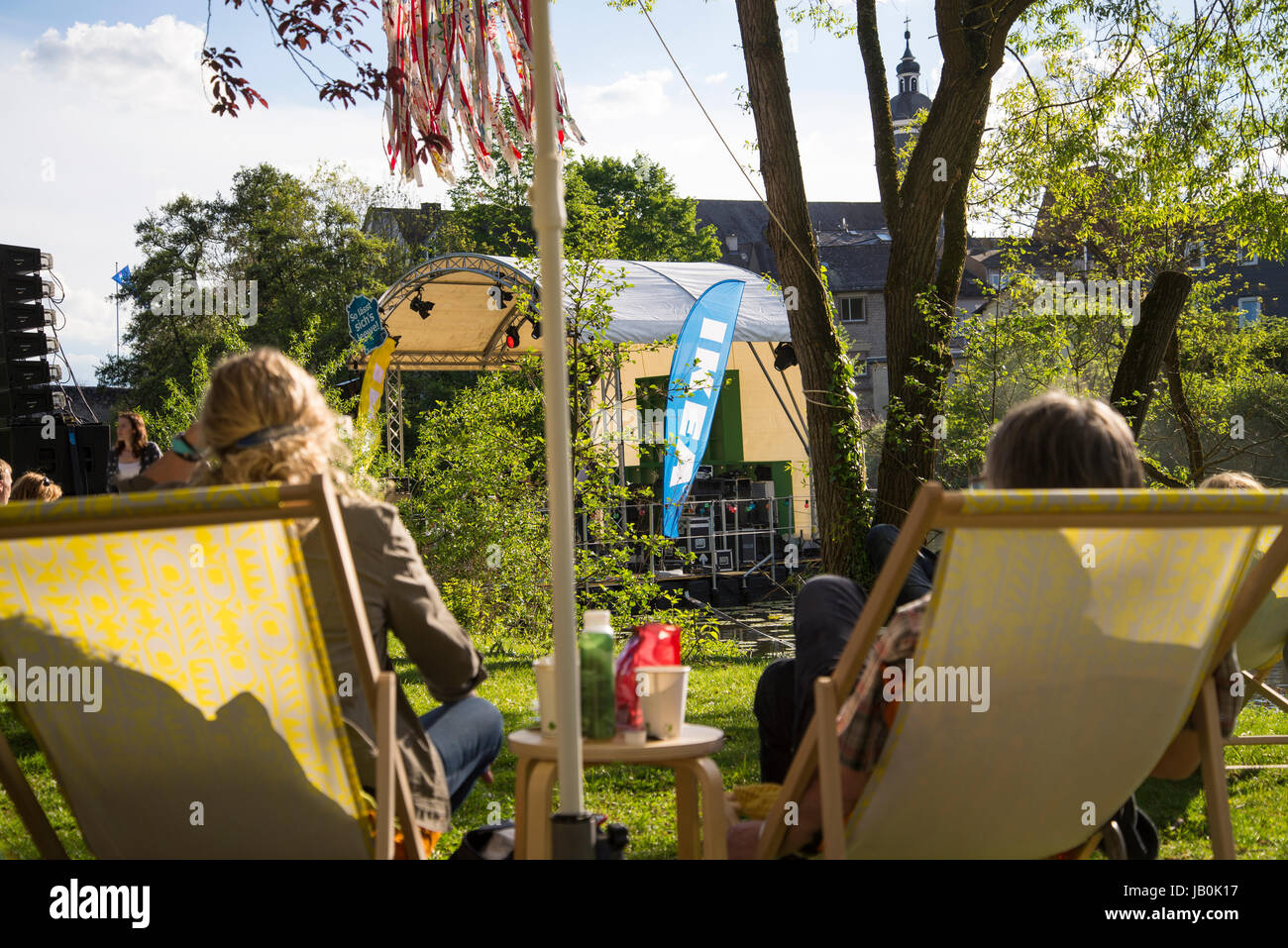 Deux chaises avec des personnes et une scène avec Ikea drapeau dans l'arrière-plan. Au cours d'un événement en plein air de la société sur les rives de la Lahn dans Wetzla Banque D'Images