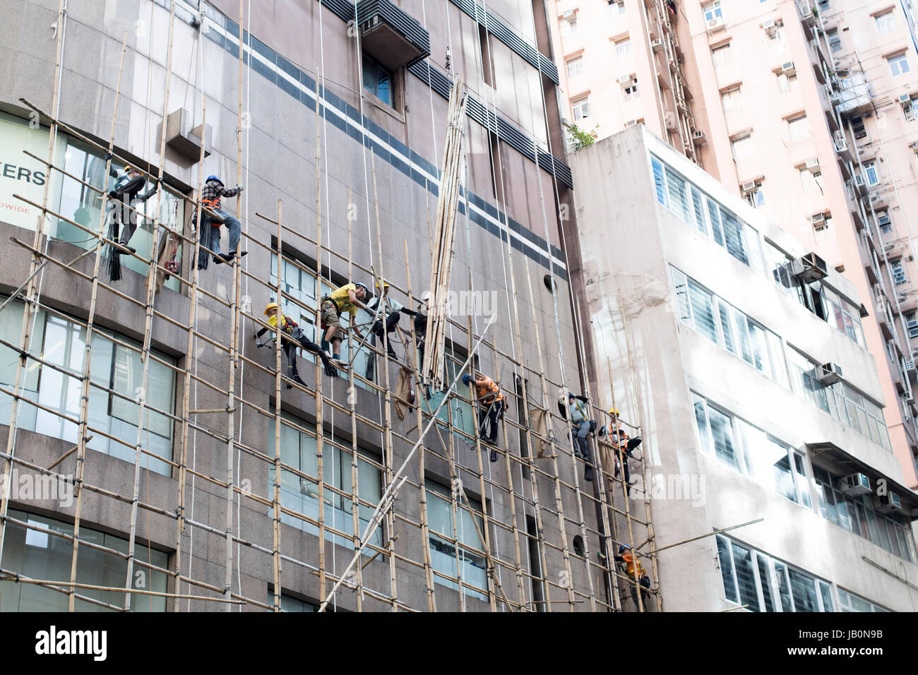 La construction d'échafaudages en bambou travailleurs à l'extérieur d'un bâtiment. . Banque D'Images