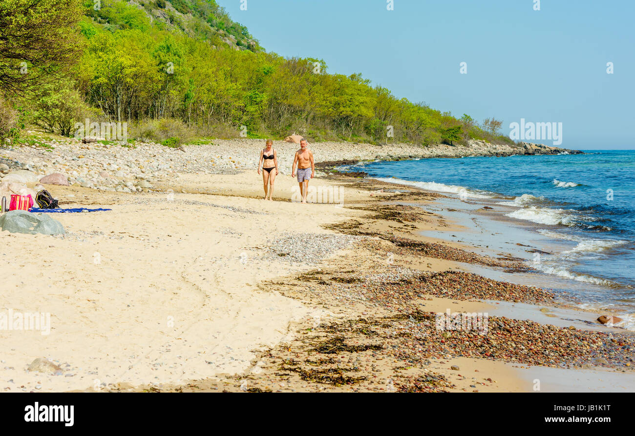 Le parc national de Stenshuvud, Suède - 20 mai 2017 : l'environnement documentaire. Hot couple en train de marcher vers vous sur la plage. Forêt de hêtres en arrière-plan. Banque D'Images Le parc national de Stenshuvud, Suède - 20 mai 2017 : l'environnement documentaire. Hot couple en train de marcher vers vous sur la plage. Forêt de hêtres en arrière-plan. Banque D'Images