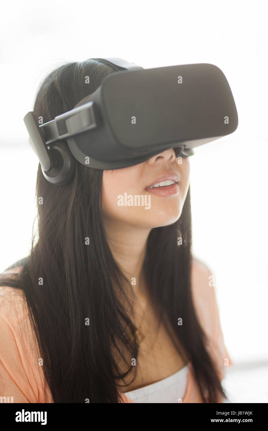 Young Asian woman wearing casque de réalité virtuelle oculus rift et démontrer comment utiliser la commande tactile Banque D'Images