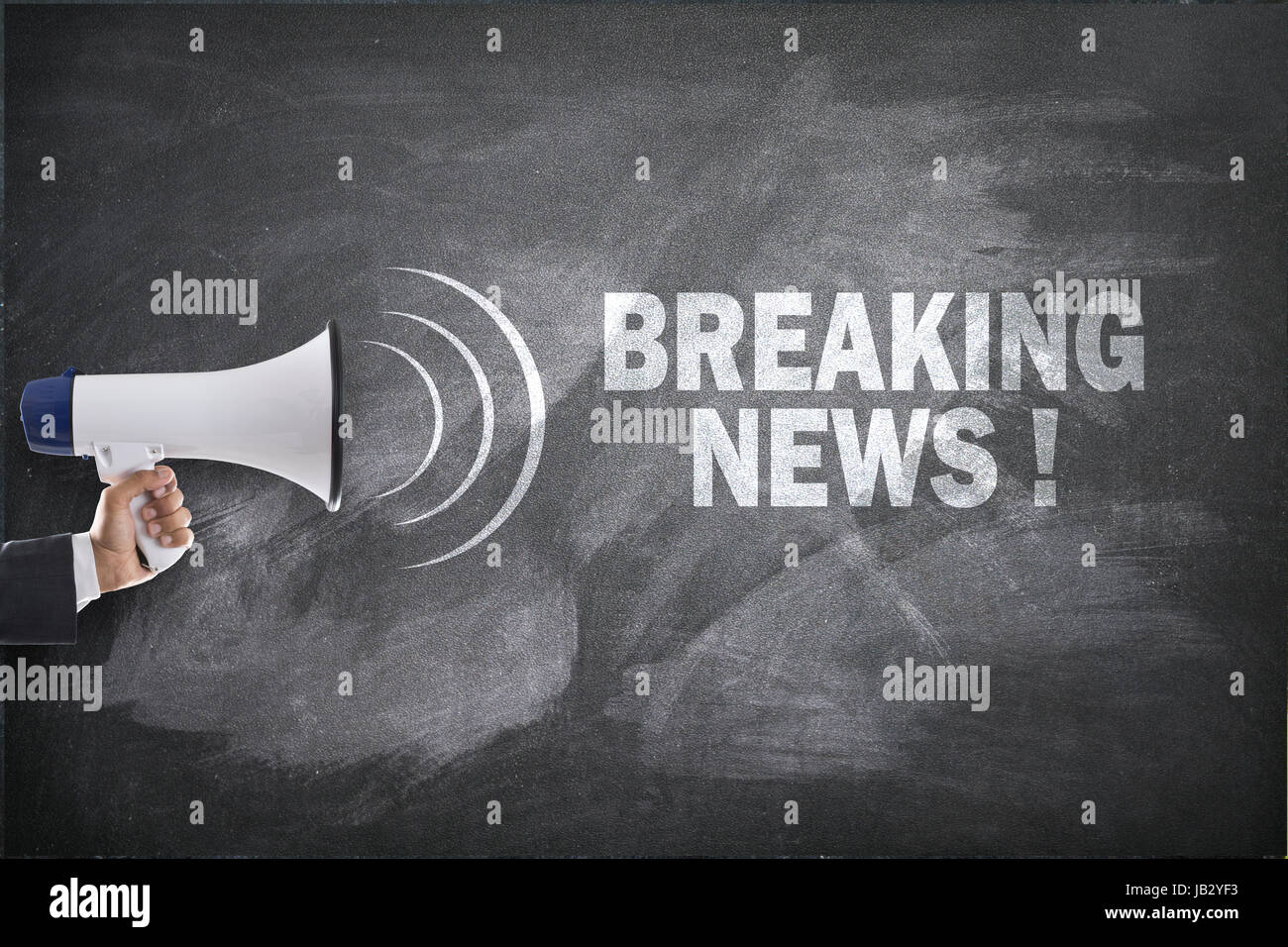Homme tenant un mégaphone in front of blackboard avec breaking news text Banque D'Images