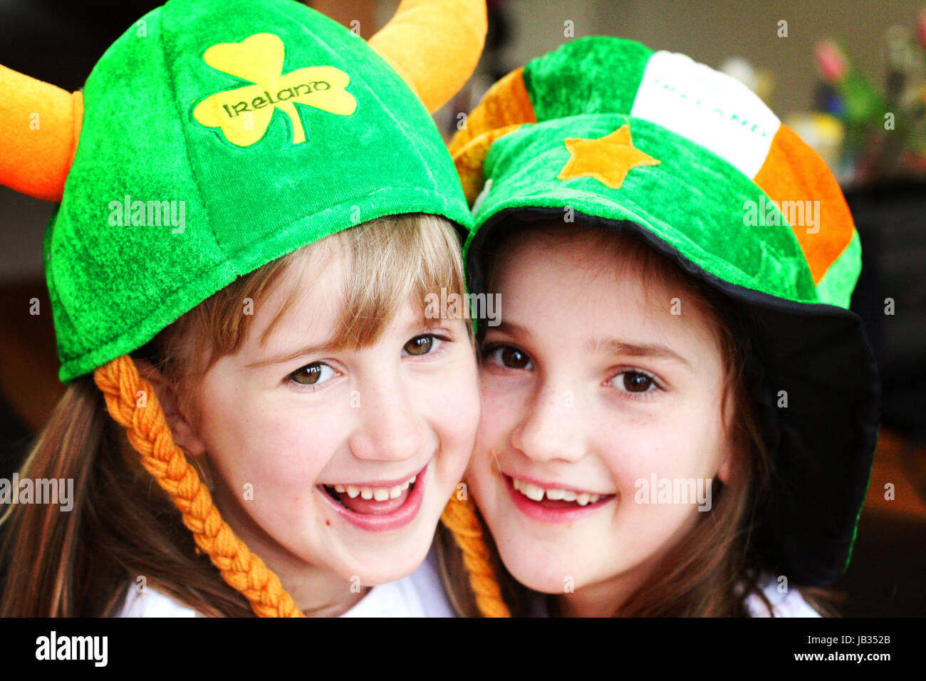 Deux jeunes filles, enfants hugging portant le jour de la Saint Patrick chapeau dans Dublin Ireland Banque D'Images