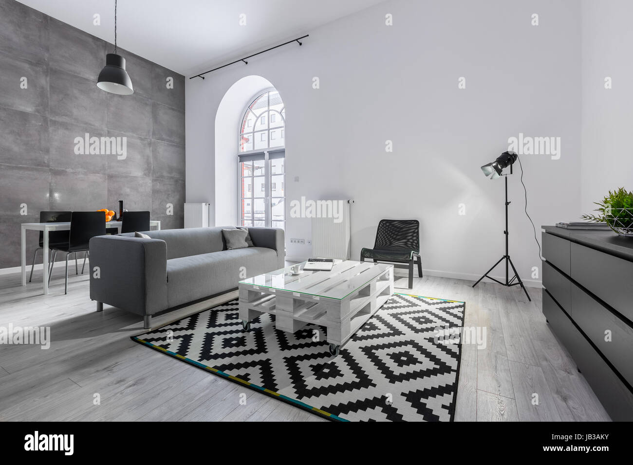Gris et Blanc loft avec canapé, table, palettes et tapis lampe studio Banque D'Images