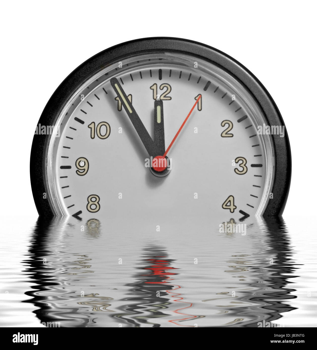 Une horloge encastrée en partie montrant cinq minutes à douze sur la surface de l'eau réfléchissante à dos blanc Banque D'Images