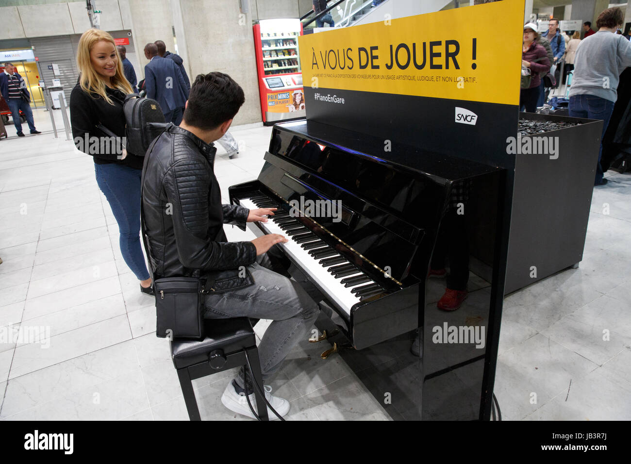 Un homme jouant du piano dans un espace public, l'aéroport Roissy Charles  de Gaulle, Paris, France Photo Stock - Alamy
