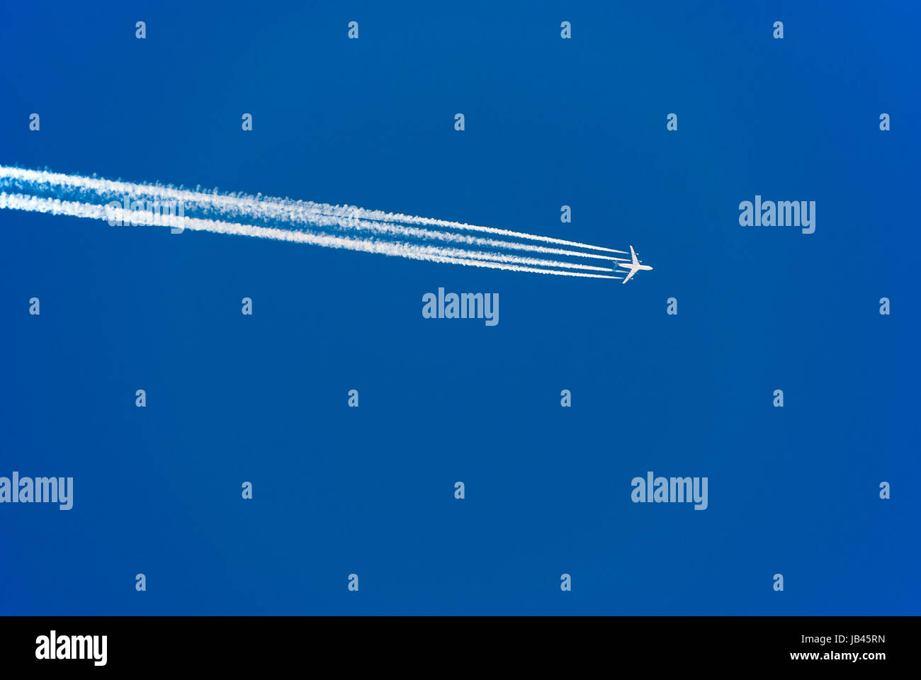 Flugzeug mit vier Triebwerken Kondensstreifen und am blauen Himmel ; avion avec quatre moteurs à réaction et les traînées de condensation dans le ciel bleu Banque D'Images