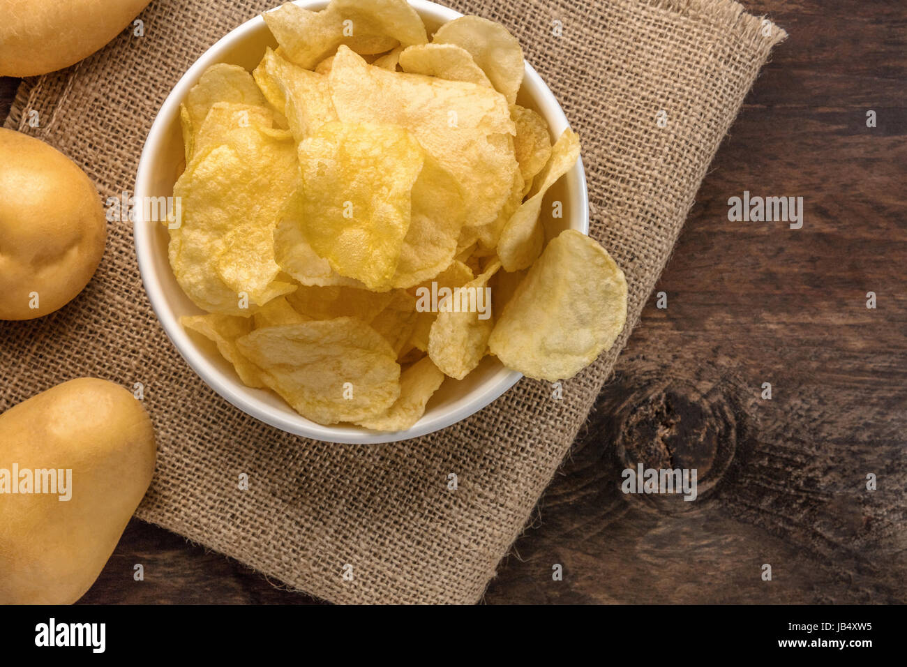 Une photo d'un bol de croustilles de pommes de terre, tourné à partir de ci-dessus sur la texture rustique foncé, avec une place pour le texte Banque D'Images