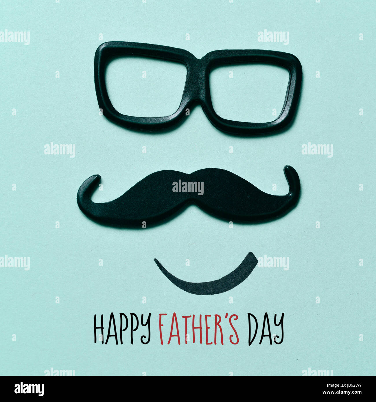 Une moustache et une paire de lunettes formant la face d'homme, et l'happy fathers day sur fond vert. Banque D'Images