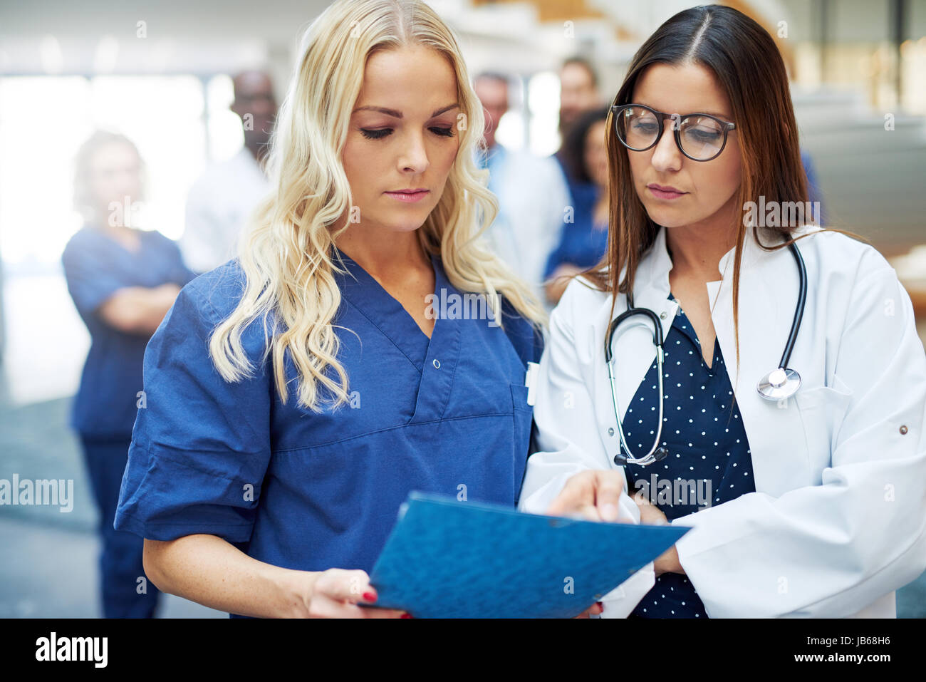Deux jeunes femmes à la recherche en communications tout en réflexion sur le diagnostic. Banque D'Images