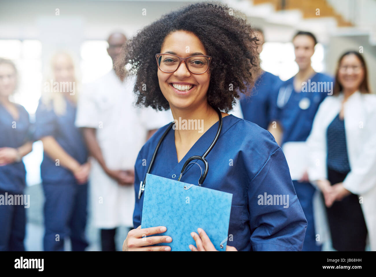 Black female doctor standing dans un hôpital smiling at camera. L'équipe médicale multiraciale mixte Banque D'Images