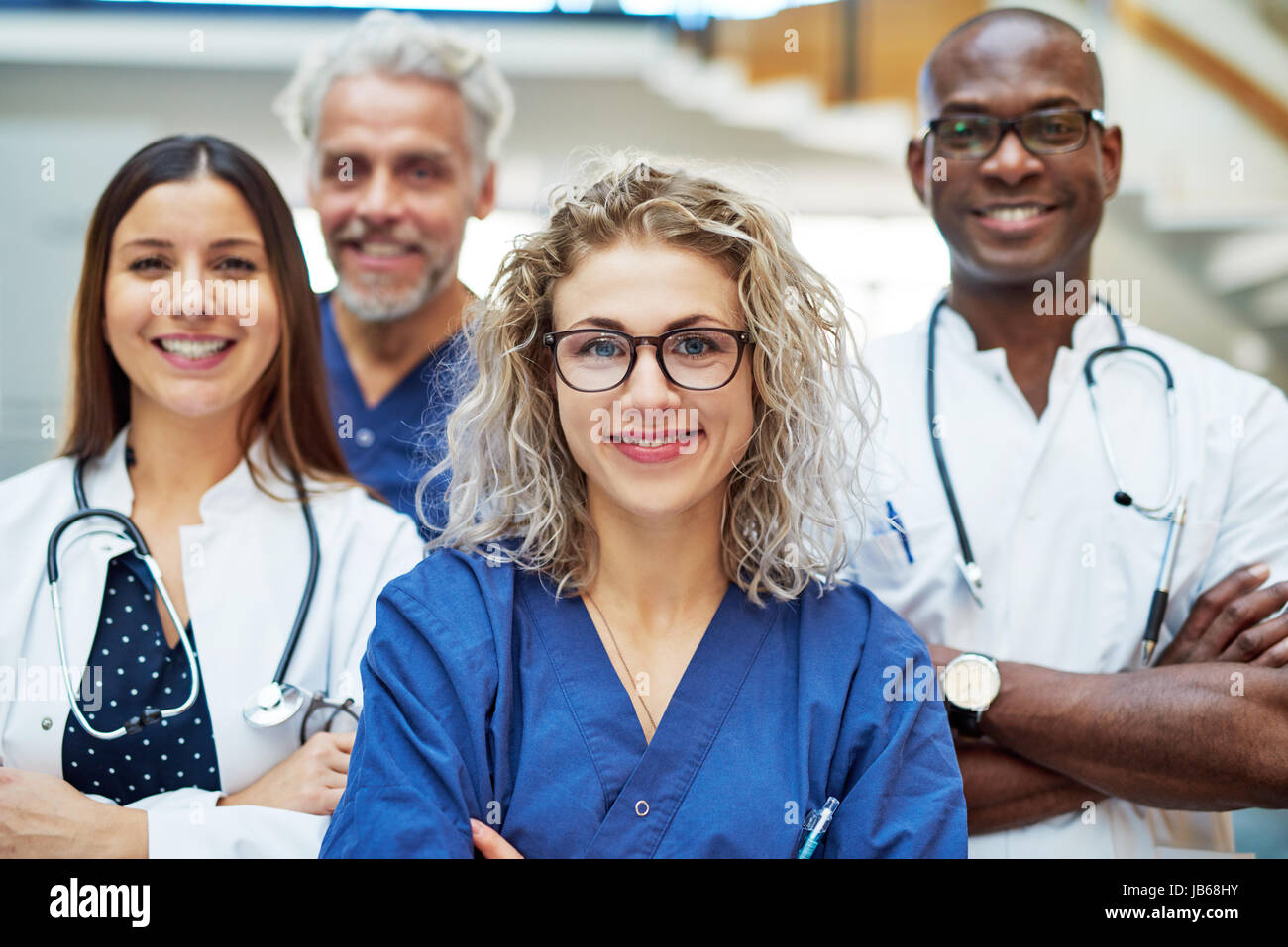 Les personnes qui travaillent dans le joyeux medicine looking at camera with à l'hôpital. Équipe de médecins positif Banque D'Images