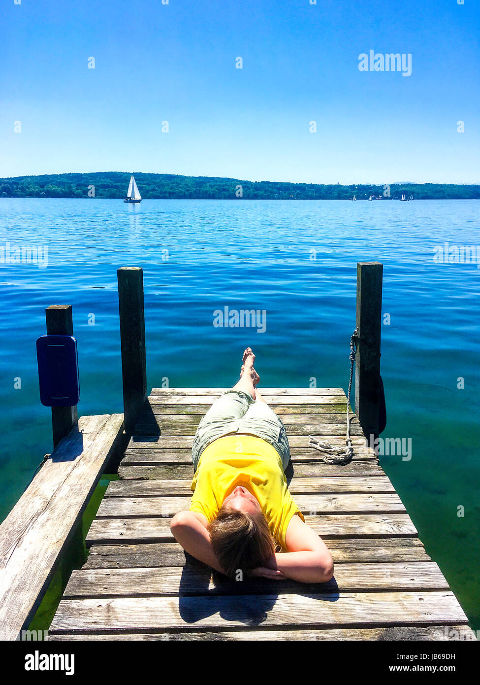 Relaxed woman bronzer sur une jetée au bord d'un lac Banque D'Images