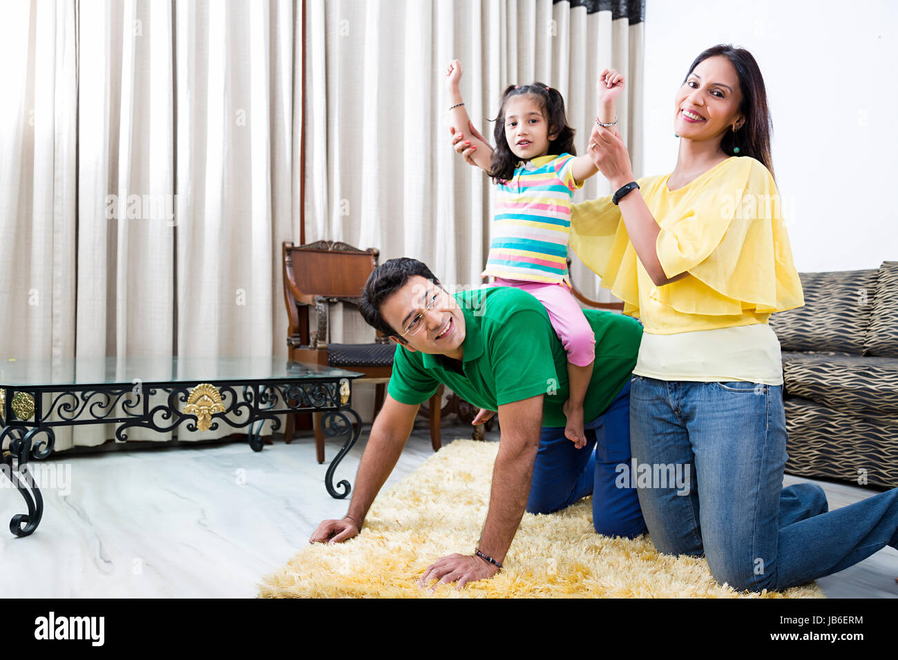 3 personnes à la maison père enfant mère fille fille équitation ludique Banque D'Images