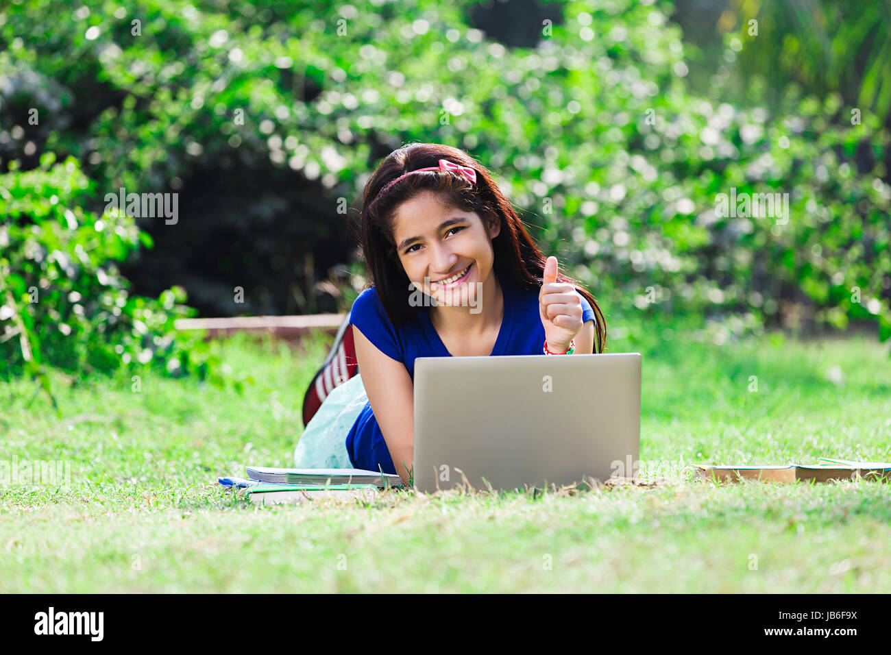 1 Indian college girl student using laptop and showing Thumbs up étudier au park Banque D'Images