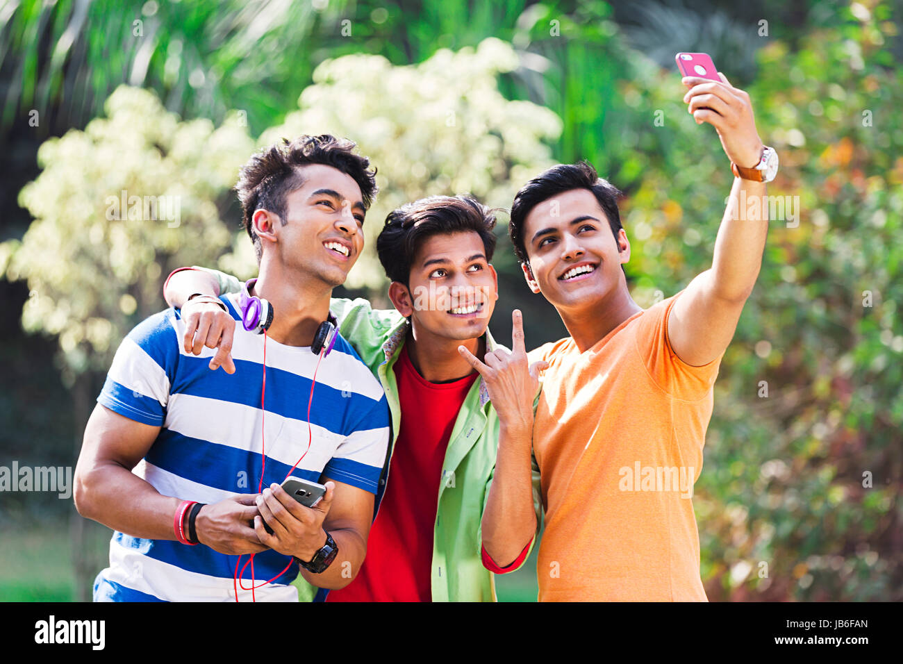 3 Indian college boys friends téléphone selfies dans park Banque D'Images