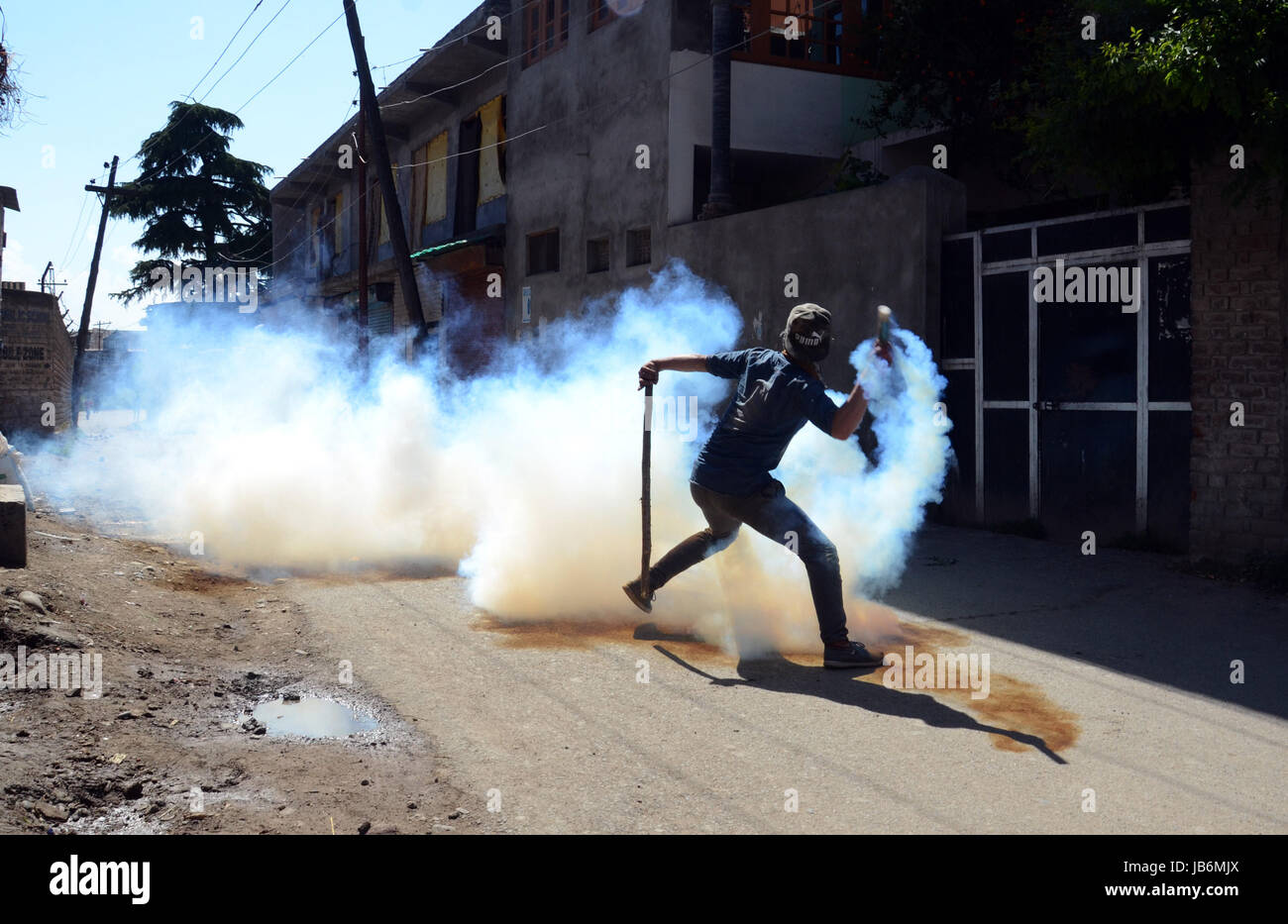 Srinagar, au Cachemire. Jun 9, 2017. Un Cachemire masqués émet une fumée lacrymogène éclatée à shell police indienne au cours d'affrontements. Les autorités ont imposé un couvre-feu-comme des restrictions dans certaines parties du Cachemire vendredi pour empêcher les manifestations contre l'appelle des séparatistes de l'assassinat d'un des jeunes musulmans du Cachemire Adil farooq Magray. Magray aurait été abattu après forces du gouvernement indien ont ouvert le feu pour disperser des manifestants tentant de perturber un fonctionnement militant dans Ganawpora dans village sud Shopian. Credit : Sofi suhail/Alamy Live News Banque D'Images